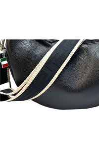 Zwarte leren tas met een gestructureerde afwerking, voorzien van een brede gestreepte schouderband in zwart en roomkleurig, en een charme in de Italiaanse vlag.