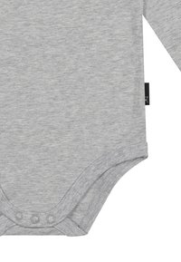 Helles graues Langarm-Babybody mit drei Druckknöpfen im Schritt und einem kleinen schwarzen Stoffetikett an der Seitennaht.