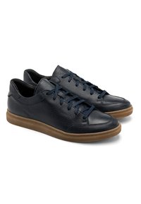 Tenisi din piele cu superior texturat de culoare albastru închis, șireturi bleumarin și o talpă din cauciuc bej contrastant. Design elegant, de tip low-top, cu accente minime.