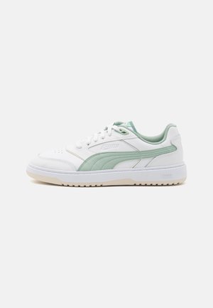 White sneakers with green accents, made of smooth leather. Features include perforated toe, textured sides, and a rubber outsole.