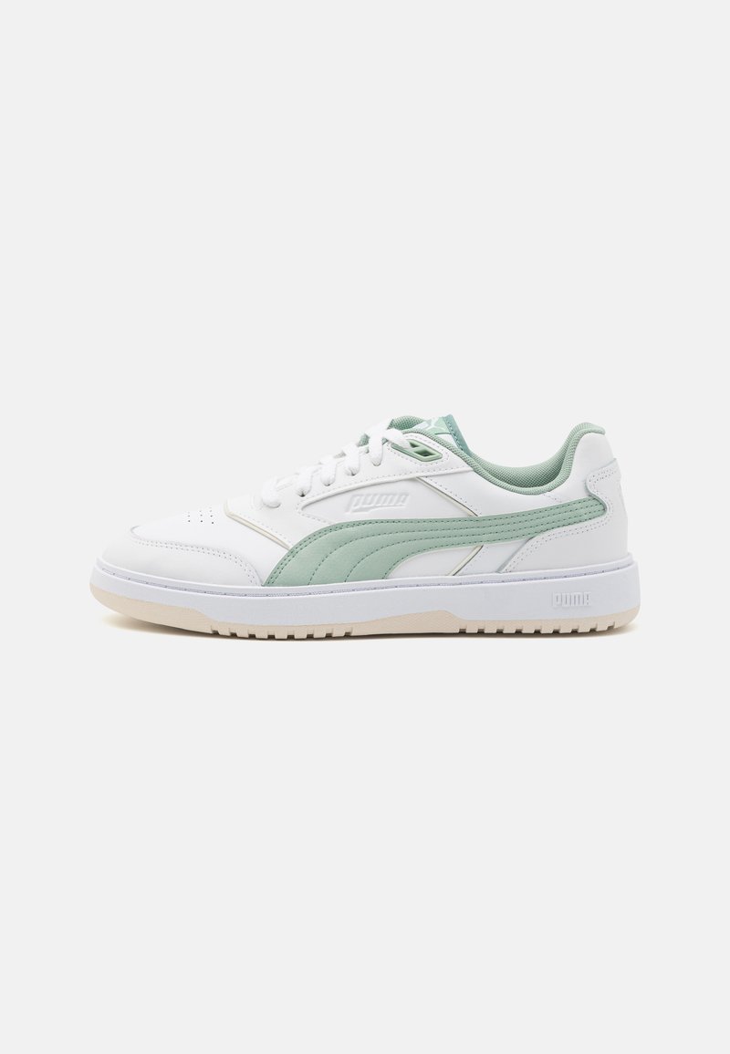 Witte sneakers met groene accenten, gemaakt van glad leer. Kenmerken zijn een geperforeerde neus, textuur op de zijkanten en een rubberen zool.
