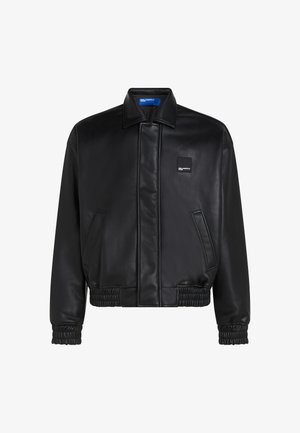 Must must lamba jakker, millel on lame krae, elastsed mansetid ja alläär. Omab külgtaskuid ja väikest brändilogo rinna peal.