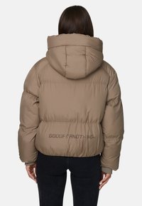 Brązowa kurtka puchowa z kapturem, z pikowanym ociepleniem i prążkowanymi mankietami. Logo nadrukowane na plecach. Gładka tekstura i skrócony krój.