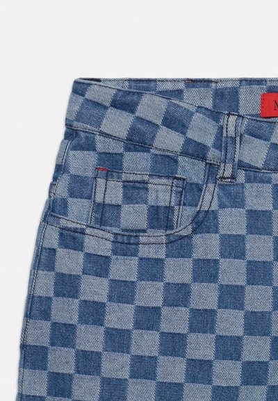 Short en jean avec un motif damier bleu et bleu clair, poche avant, passants de ceinture et un petit détail de couture rouge près de la poche.
