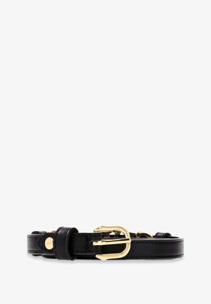 Czarny skórzany pasek z pozłacaną klamrą i małym złotym guzikiem, ułożony płasko na białym tle.
