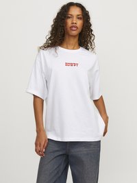 Camiseta de algodón blanca de manga corta con el texto "HOWDY" en rojo. Corte relajado con un escote redondo y una textura de tela suave.