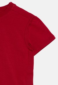 Rød bomulds t-shirt med korte ærmer, rundt halsudskæring, flade sømme og en glat overflade. Har en let afslappet pasform.