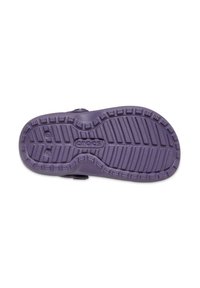 Semelle en Crocs violette avec un motif texturé, présentant une forme ergonomique et des trous de drainage. Matériau lisse avec un design léger.