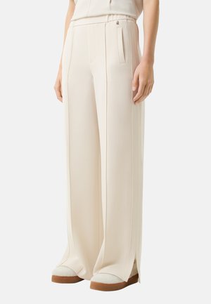Pantalons larges crème en tissu lisse, dotés d'une taille haute, de poches latérales et d'ourlets fendus. Accent u avec un petit logo.