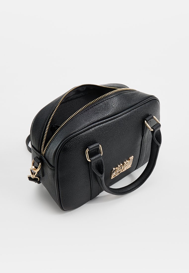 Sac à main en cuir texturé noir avec une fermeture éclair dorée partiellement ouverte, deux poignées et un logo décoratif doré à l'avant.