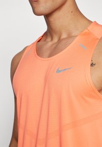 Nike Performance RISE TANK - Top - light wild mango/reflective silver
