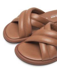 Sandales en cuir marron avec un design tressé et une semelle arrondie. Texture douce avec des détails de couture et une finition lisse et soignée.