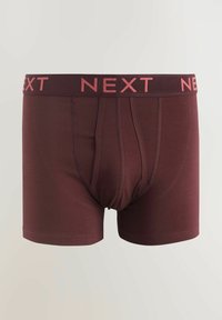Chiloți boxer burgundy cu o talie elastică neagră și roz, având imprimeul „NEXT” repetat. Material neted cu un design mulat.