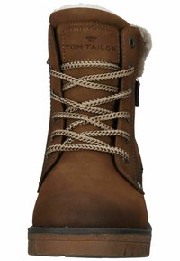 Botas de tobillo de cuero marrón con un suave forro de lana blanca, ojales de metal y cordones trenzados; cuenta con un logo en la lengüeta.