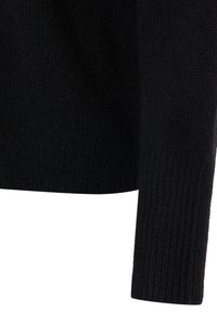 Pull noir en tricot avec un motif texturé, manches longues et coupe décontractée. Le matériau semble doux et chaud.