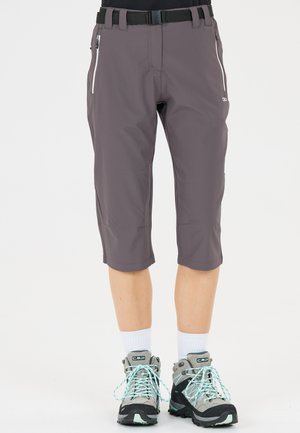 Person iført grå knælange shorts med sort bælte, hvide sokker og grå vandrestøvler med lyseblå snørebånd.