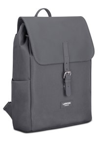 Sac à dos gris de forme rectangulaire, fabriqué en tissu durable. Il dispose d'une fermeture à rabat avec une sangle et une boucle en métal. Poches latérales incluses.