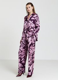 Set di pigiama in satin con un motivo floreale in tonalità di rosa e viola. Comprende una camicia a maniche lunghe con bottoni e pantaloni a gamba larga.