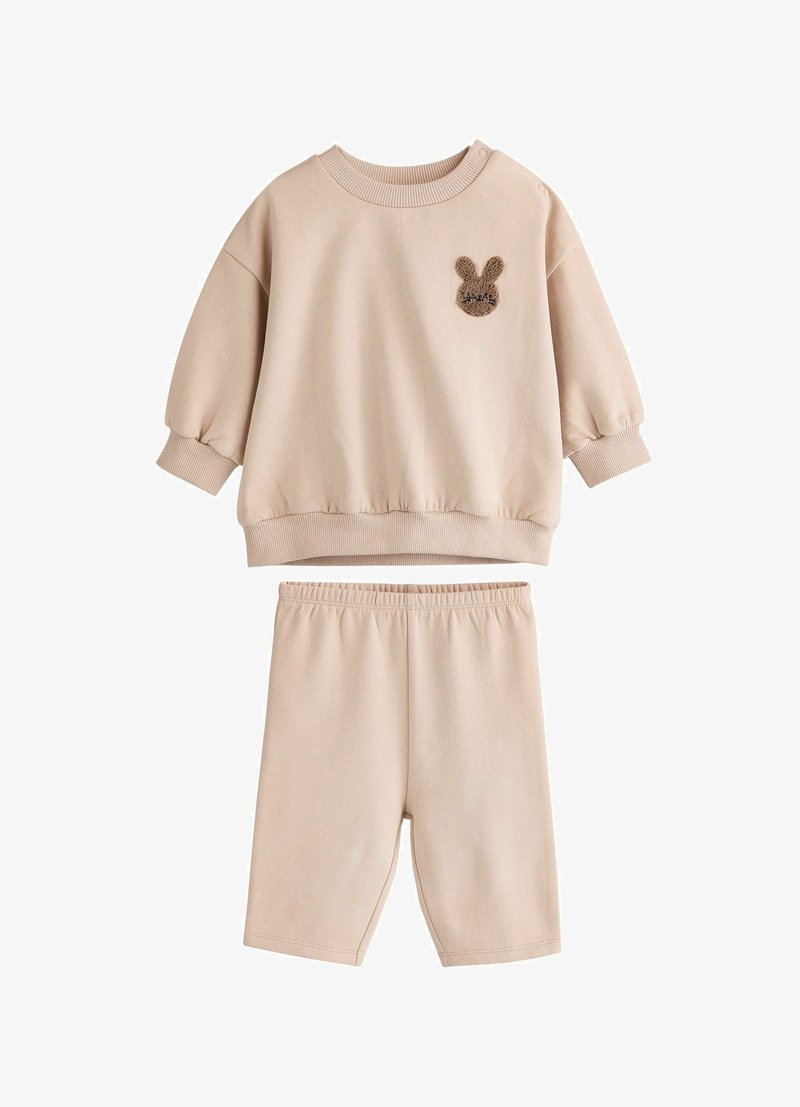 Set de hanorac și șorturi bej. Hanoracul are gât rotund, umeri lăsați și o aplicație țesută în formă de iepure. Șorturile au o talie elastică.