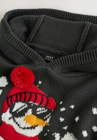 Dunkelgrauer Strickpullover mit einem Schneemann-Design, ausgestattet mit einem roten Hut und Pompon sowie kontrastierenden weißen und orangen Details. Etikett sichtbar, bezeichnet mit "NEXT."