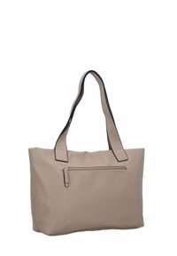 Sac fourre-tout beige avec deux poignées bordées de noir, une poche avant zippée et une texture douce. Forme carrée avec une apparence structurée.