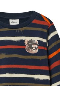 Zebra sweter w kolorze granatowym, pomarańczowym i oliwkowym z teksturowaną łatą w kształcie misia noszącego okulary przeciwsłoneczne i czapkę z przodu.
