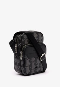 Black geometric-patterned crossbody bag with dual zippered compartments, adjustable strap, and smooth black accents. Textured material.