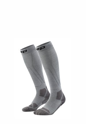 Pair of gray, knee-high athletic compression socks with patterns for support and brand logo near the top.