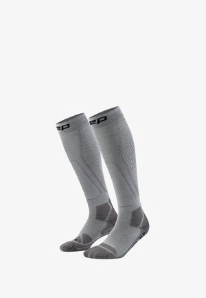 Pair of gray, knee-high athletic compression socks with patterns for support and brand logo near the top.
