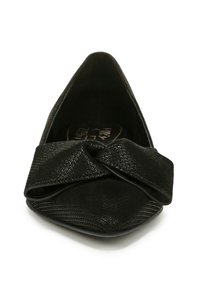 Chaussure plate noire à bout pointu, présentant un matériau texturé avec un détail de nœud torsadé à l'avant, une doublure intérieure lisse et un design minimaliste.