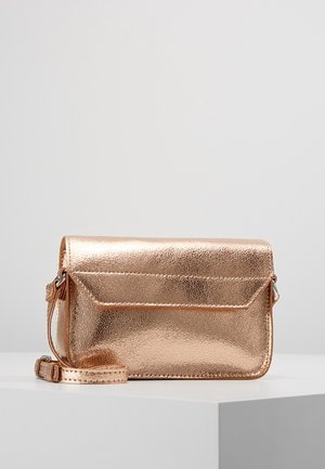 Kleine metallic roségouden leren crossbodytas met klepsluiting en verstelbare riem op witte ondergrond.
