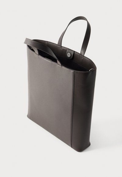 Ψηλή σκούρα γκρι δερμάτινη τσάντα ώμου με δύο χερούλια, ανοιχτό πάνω μέρος με κούμπωμα κουμπιού και απλό, μινιμαλιστικό σχέδιο.