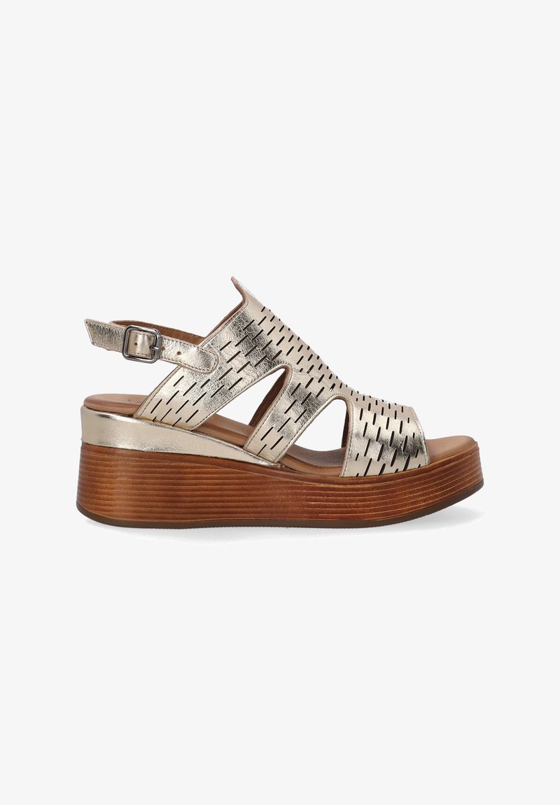 Sandy s otevřenou špičkou a kovově stříbrným svrškem, s prořezávaným designem, nastavitelným páskem kolem kotníku a texturovanou dřevěnou podrážkou.
