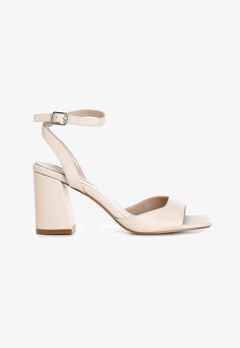 Beige sandal med åben tå, høje hæle, ankelrem med sølvspænde, blokhæl og glat læderfinish.