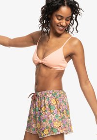 Gaiši rozā ribota bikini augšdaļa ar mezglu, saskaņota ar daudzkrāsaini ziedu printa šortiem, kas aprīkoti ar stringa jostu un mežģīņu apdari.