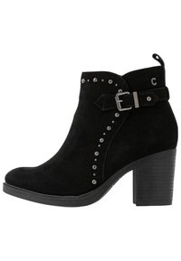 Botín de ante negro con tacón apilado, detalles de tachuelas a lo largo del costado y una correa decorativa con un acento de hebilla.