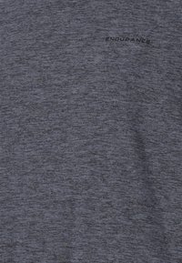 Miesten urheilupaita tumman heather-harmaana, jossa on sileä pinta ja sana "KESTÄVYYS" painettuna mustana rinnan kohdalle.