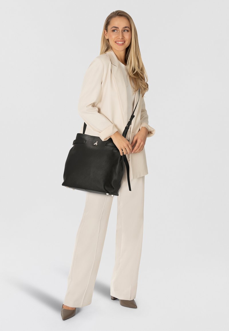 Schwarze Lederschultertasche mit einem oberen Griff und abnehmbarem Riemen. Glatte Textur, minimalistisches Design, mit einem silbernen Akzent auf der Vorderseite.