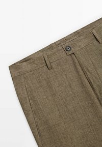Pantalon en lin marron avec passants de ceinture, fermeture par bouton et poches latérales montré sur fond blanc.