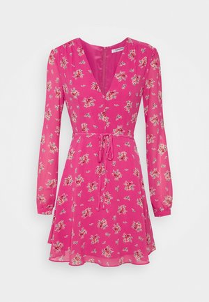 Pink long-sleeve mini dress with small floral prints, V-neck, fitted waist with tie belt, and slightly flared skirt.