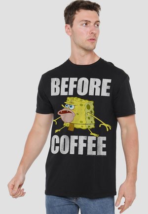 Man wearing black t-shirt with cartoon sponge character and bold white text reading "BEFORE COFFEE" on a plain background.