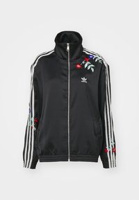 Svart satin sportjacka med hög krage, framtida blixtlås, vita ränder på ärmarna och flerfärgad blommönsterbroderi som detalj.