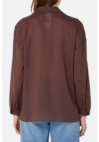 Camicia marrone a maniche lunghe realizzata in tessuto leggero, con una vestibilità comoda, dettagli a yoke sul retro e polsini con bottoni.