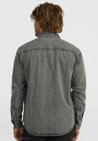 Gray denim shirt with a button-down collar, long sleeves, and stitched detailing at the cuffs and back. Soft texture, casual design.