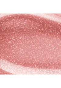 Campione liscio di trucco rosa lucido e scintillante o gloss per labbra con fini glitter bianchi distribuiti in modo uniforme sulla superficie.
