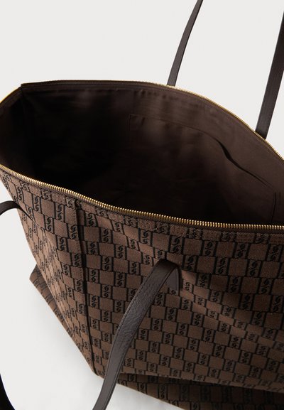 Sac cabas marron avec motif à carreaux foncés, poignées en cuir, fermeture éclair ouverte en haut et intérieur en tissu foncé spacieux avec poche intérieure.