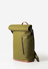 Zaino a sacco verde oliva con finitura texture, presenta una tasca frontale con zip, dettagli in pelle color cuoio e spallacci regolabili.