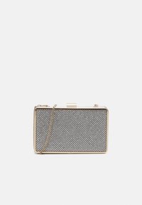 Suuri kultainen käsilaukku, jossa on hopeisia strasseja ja kultaketju, asetettuna yksinkertaista valkoista taustaa vasten.