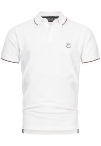 Polo shirt blanc en coton, avec un col à deux boutons, des manches courtes avec un bord rouge, et un petit logo sur la poitrine.