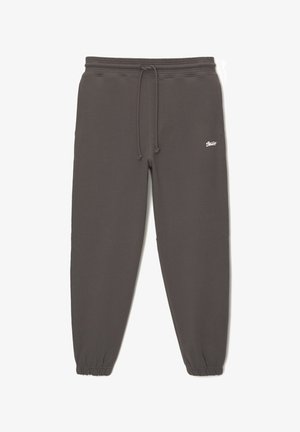 Pantaloni de trening gri din bumbac, cu talie elastică și șnur. Mansetele sunt de asemenea elastice. Prezintă un mic logo alb lângă talie.